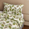 Cubrecama crema con estampado floral verde sobre una cama