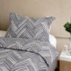 Cubrecama gris con estampado líneas hueso sobre una cama