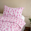 Cubrecama rosado con estampado floral fucsia sobre una cama