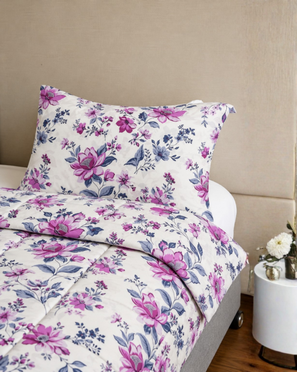 Cubrecama hueso con estampado floral morado sobre una cama