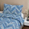 Cubrecama celeste con estampado líneal turquesa sobre una cama