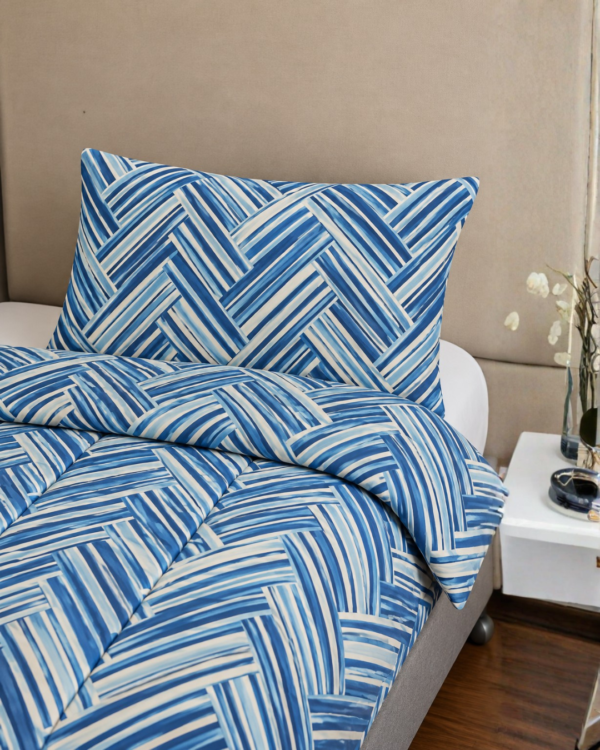 Cubrecama celeste con estampado líneal turquesa sobre una cama