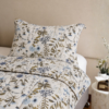 Cubrecama hueso con estampado floral verde sobre una cama