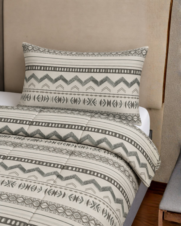 Cubrecama hueso con estampado tribu gris sobre una cama