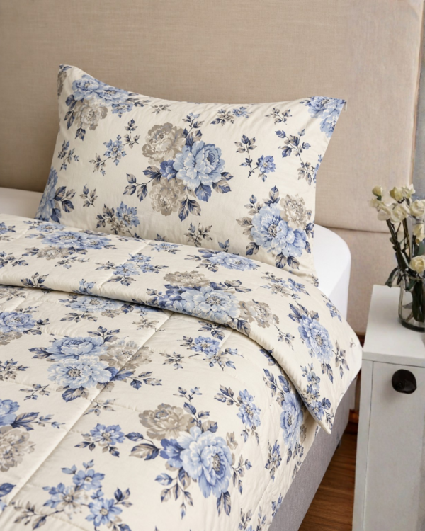 Cubrecama hueso con estampado floral celeste sobre una cama
