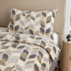 Cubrecama hueso con estampado floral marrón sobre una cama