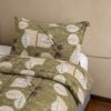 Cubrecama verde con estampado floral beige sobre una cama