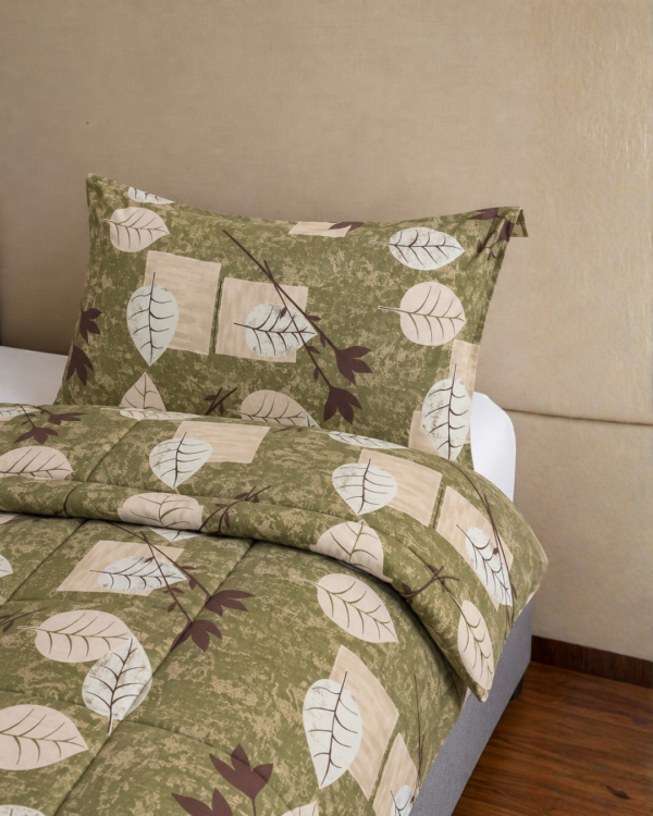 Cubrecama verde con estampado floral beige sobre una cama