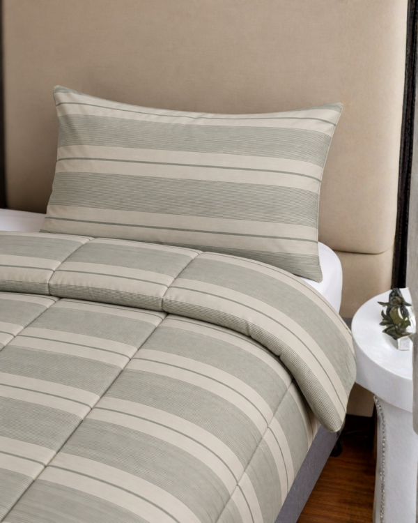 Cubrecama gris con estampado líneal sobre una cama