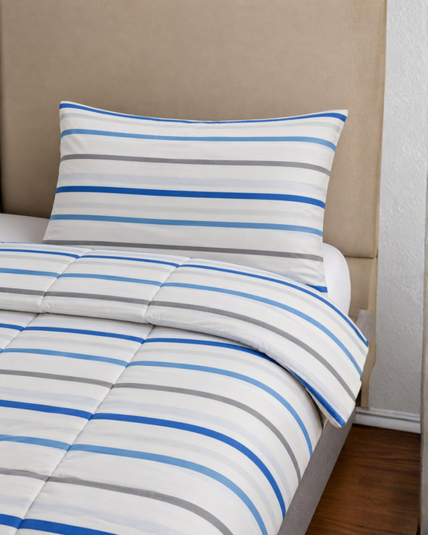 Cubrecama blanco con estampado líneal turquesa sobre una cama