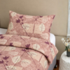 Cubrecama guinda con estampado hojas guinda sobre una cama