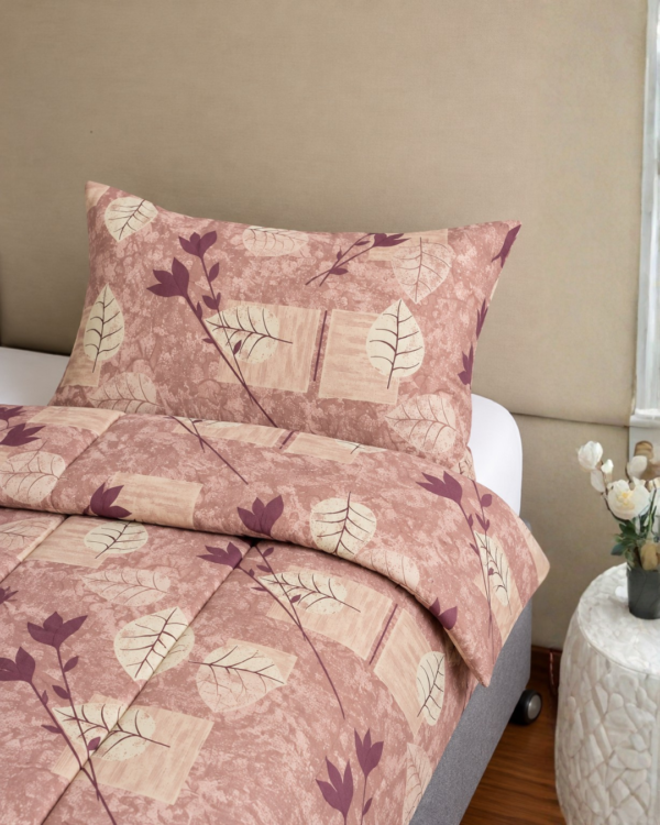 Cubrecama guinda con estampado hojas guinda sobre una cama
