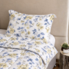 Cubrecama hueso con estampado flores amarillas sobre una cama