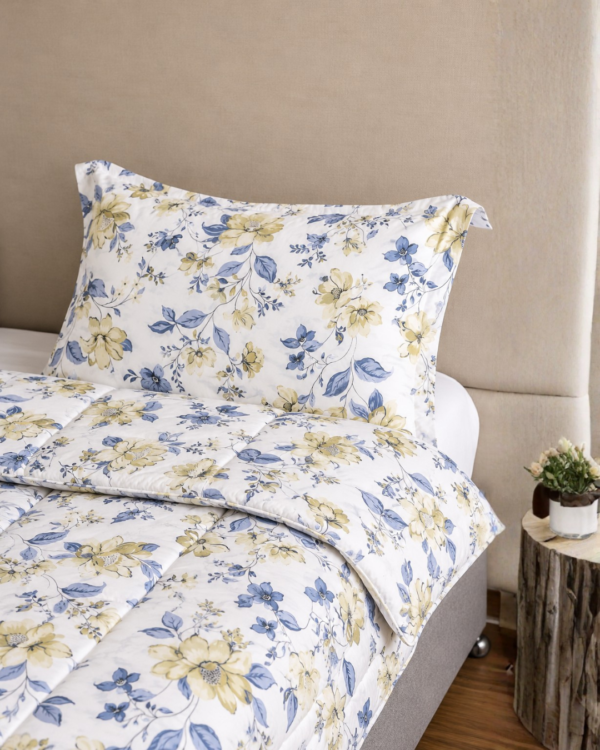 Cubrecama hueso con estampado flores amarillas sobre una cama