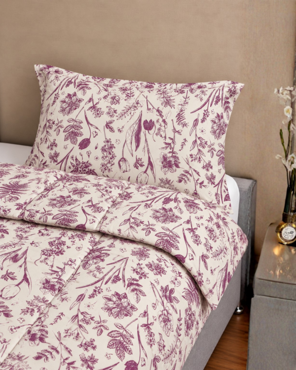 Cubrecama hueso con estampado flores guinda sobre una cama