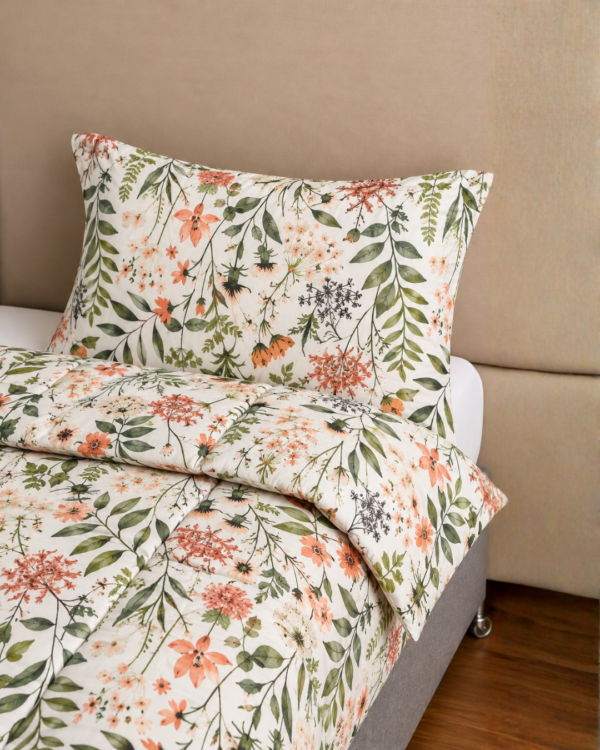 Cubrecama nude con estampado flores naranjas sobre una cama