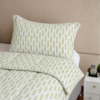 Cubrecama blanco con estampado espiga verde sobre una cama