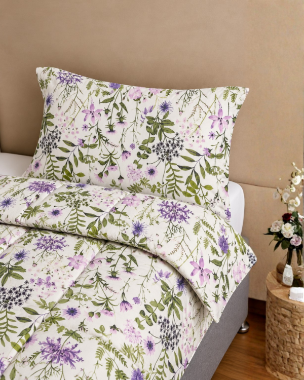 Cubrecama hueso con estampado floral lila sobre una cama