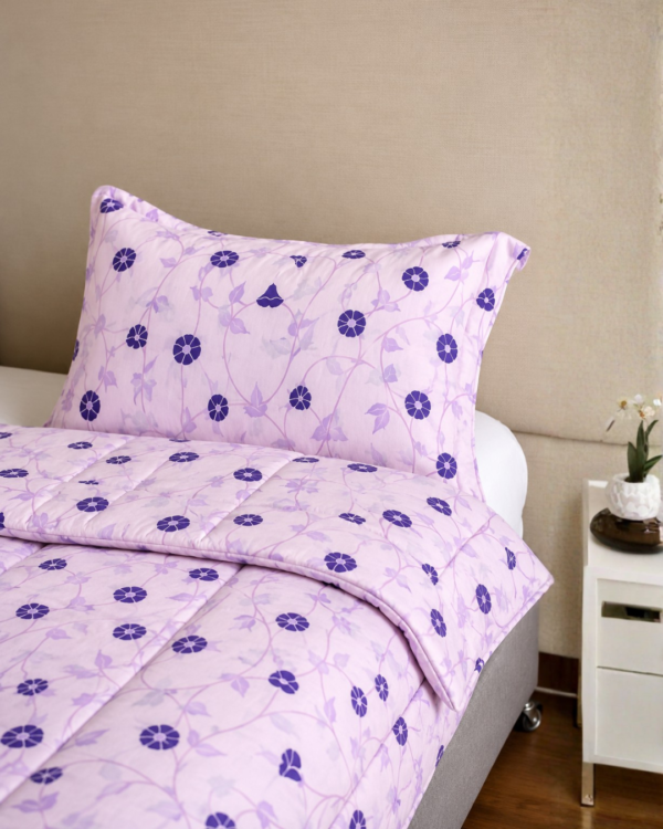 Cubrecama lila con estampado floral violeta sobre una cama